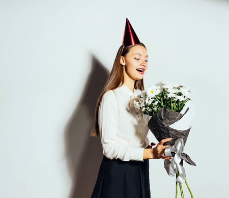 happy girl celebrating something and holding a big bouquet of white flowers in hands