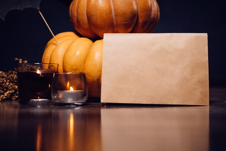 composition for decorating a house in halloween, on a wooden table lie pumpkins, burning scented candlesの写真素材