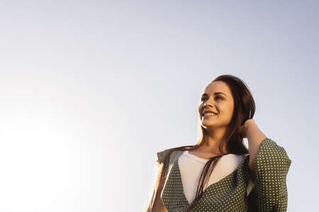 Free Happy Woman Enjoying Nature. Beauty Girl Outdoor. Freedom concept. Beauty Girl over Sky and Sun. Sunbeams. Enjoyment.の写真素材