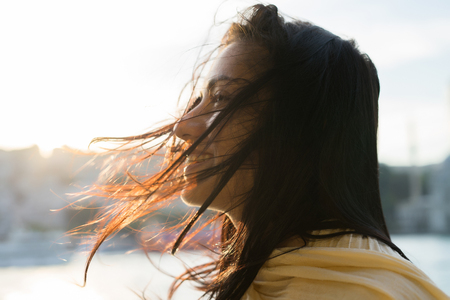Portrait of a happy girl with tangled hair, strong windの写真素材