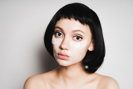beautiful girl with short black hair and with clean skin looking at the cameraの写真素材