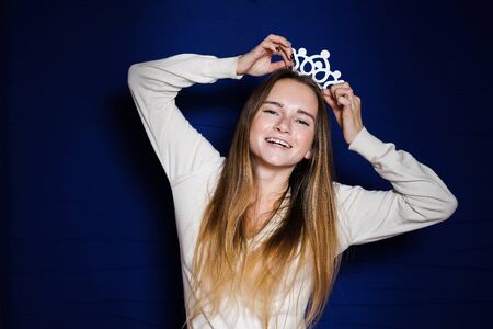 a young funny girl with long hair puts herself on a crownの写真素材