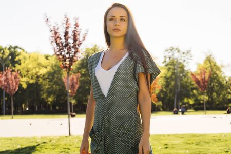 Serious upset woman in park,frustrated,in a fashionable green dressの写真素材