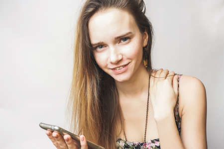 Cute summer happy young woman with smartphone smilingの写真素材