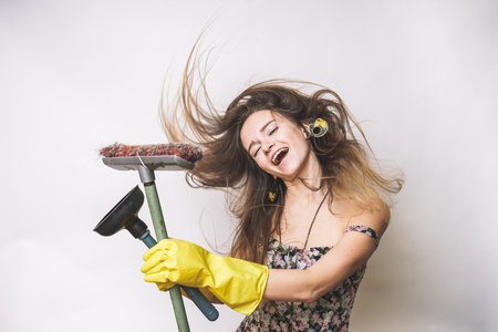 Happy Spring Cleaning lady,in yellow rubber gloves, holds a plunger and a brushの写真素材