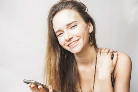 Positive summer happy young woman with smartphone smilingの写真素材