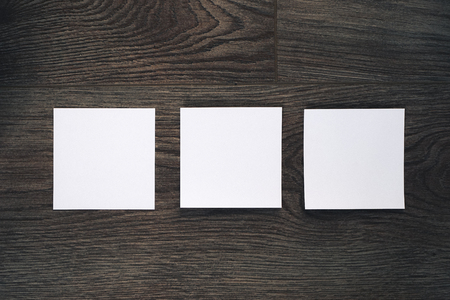 on a dark wooden surface there are three white cubesの写真素材