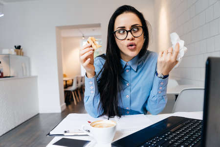 funny young business lady makes a funny face, works in a cafe, freelanceの写真素材