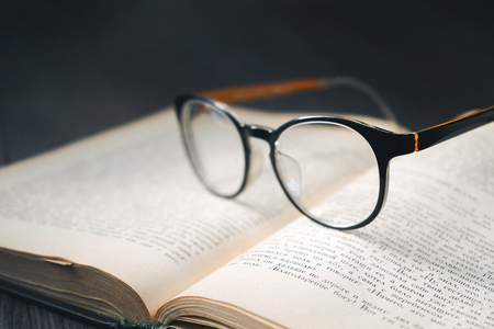 the book is on the table, on the book are glasses in black rimの写真素材