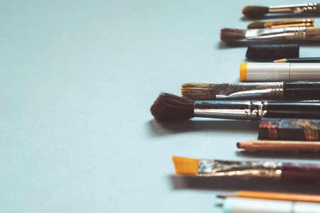 on a blue background there are artistic accessories, brushes of different sizes, pencilsの写真素材