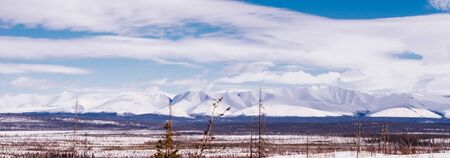 in the far north a snow-covered field against the background of the sky and mountainsの写真素材