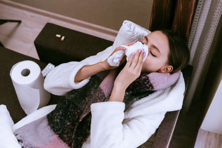 young sad girl fell ill because of cold winter weather, sore throat, sneezesの写真素材