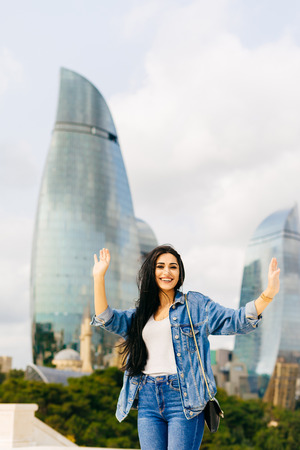 smiling happy girl raised her hands up, enjoys vacations in Baku
