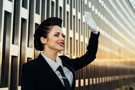 happy smiling stewardess girl looking into the distance, waiting for the flightの写真素材