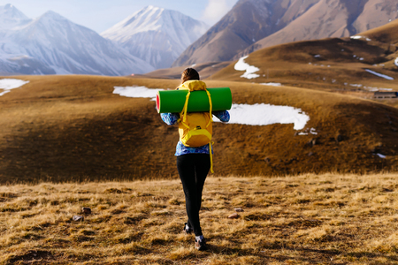 active girl leads a healthy lifestyle, travels along the Caucasian ridge with a backpackの写真素材