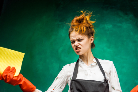 A young girl with red hair does the cleaning in the houseの写真素材