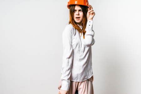 young girl in an orange helmet on a gray backgroundの写真素材