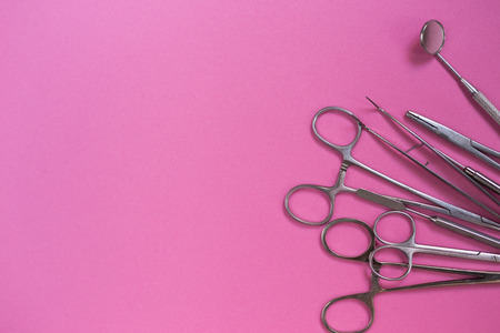 a lot of dental instruments on a pink backgroundの写真素材