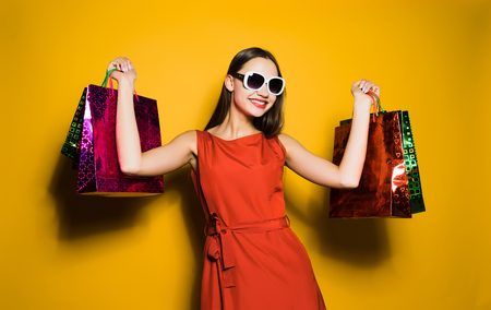 Happy young girl shopaholic in sunglasses bought a lot of giftsの写真素材