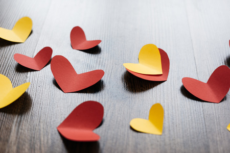 Valentine 's Day background, red and yellow hearts on wood textureの写真素材