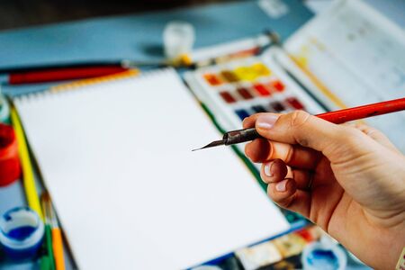 the artist draws a red paint on a white sheet of paperの写真素材