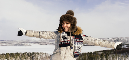 happy young girl in warm clothes is traveling in the cold northの写真素材