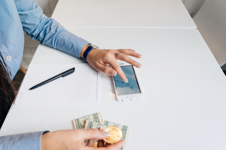 a girl in a blue shirt holds a gold bitcoin, watches graphics crypto currencyの写真素材