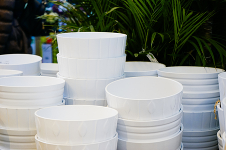 there are many white pots under the flowers and plantsの写真素材