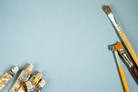 On a blue background tubes with paints and brushesの写真素材