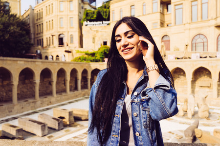 happy beautiful woman speaks by phone on building background