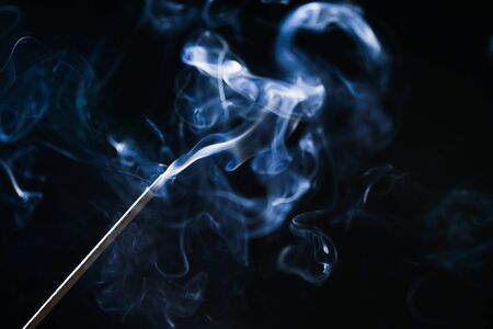 on a black background smoke incense stickの写真素材