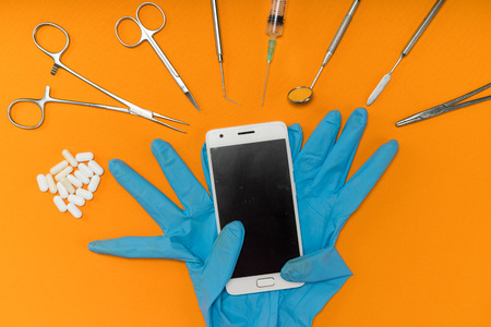 on the orange surface are dental instruments, blue gloves and tabletsの写真素材