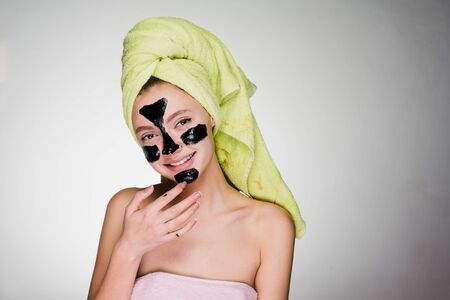 happy woman with a towel on her head after showering the mask on problem areas of the faceの写真素材