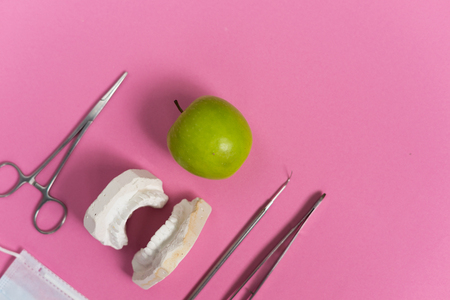 dental tools, apple lying on a pink backgroundの写真素材