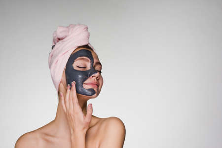 a surprised woman with a towel on her head applied a mask to her faceの写真素材