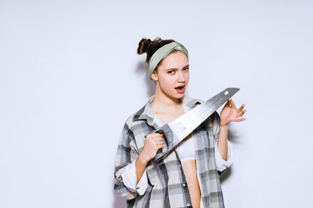 attractive young girl holding a sharp saw, wants to make repairsの写真素材