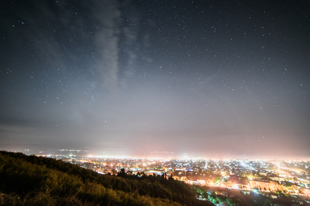 a view from above on a bright glowing city, lots of lanterns and lights under the night skyの写真素材