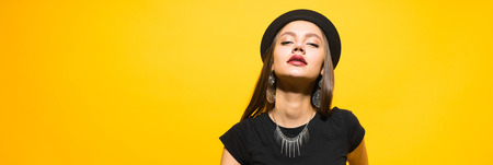 attractive luxury young girl in a black hat posing, in the ears expensive earrings