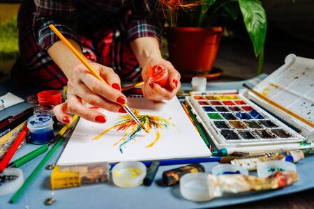 woman artist draws on a sheet of paper watercolorの写真素材