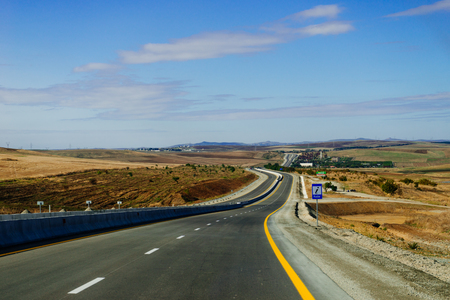 endless road, highway, yellow fields and meadows under the blue skyの写真素材