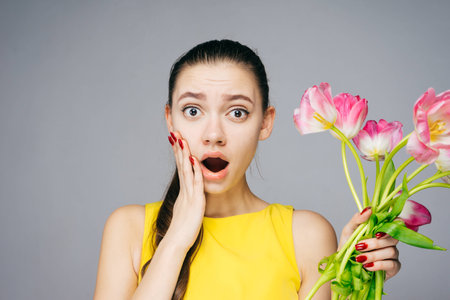 surprised woman holding beautiful flowers, March 8の写真素材