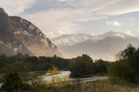 green forest against the backdrop of mountains on a sunny dayの写真素材