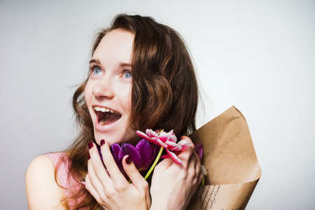 happy beautiful young woman holding flowers in her hands, March 8, mother's dayの写真素材