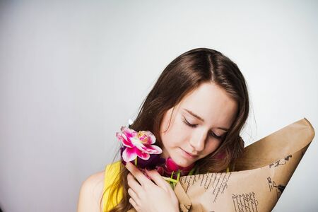 the amazed woman hugs in her hands a bouquet of tulipsの写真素材