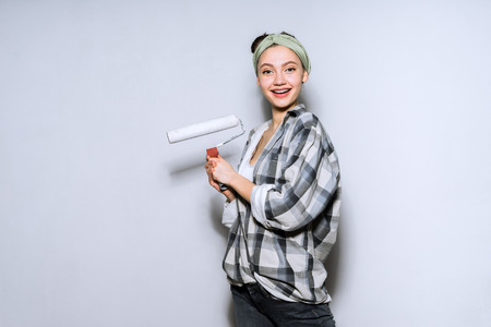 woman on a gray background preparing to paint a wallの写真素材