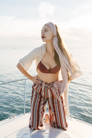 an attractive luxury girl rests on her big yacht, enjoys a vacation and the sunの写真素材