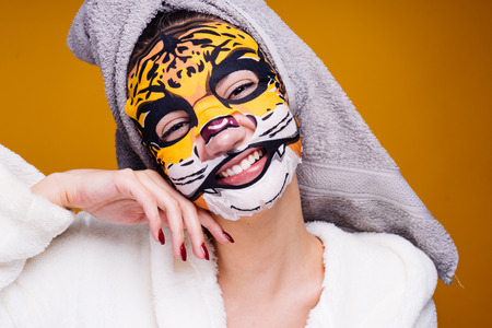 happy young girl with a towel on her head smiling, n alice mask with an animal faceの写真素材