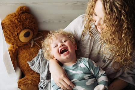 cheerful family, caring mother plays with her little son, laughs