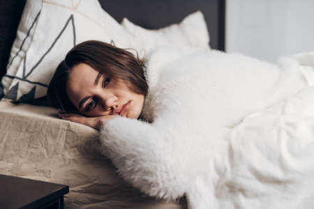 cute young girl lies in bed, tired after a hard day's work, restingの写真素材
