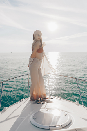 gorgeous stylish girl posing on her yacht in the sun, sailing the Caribbean seaの写真素材